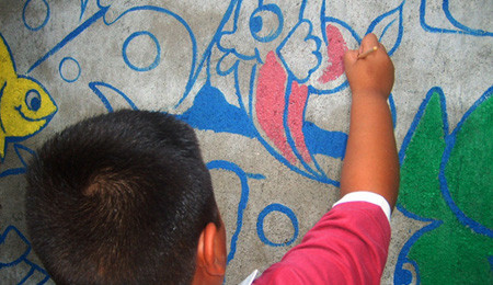 niño coloreando en mural
